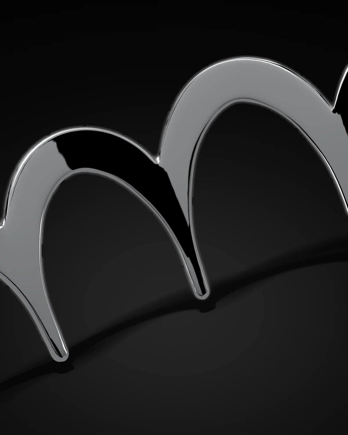 Close detail of the polished arches of the Zig Zag Hairband, crossing the frame on a diagonal
